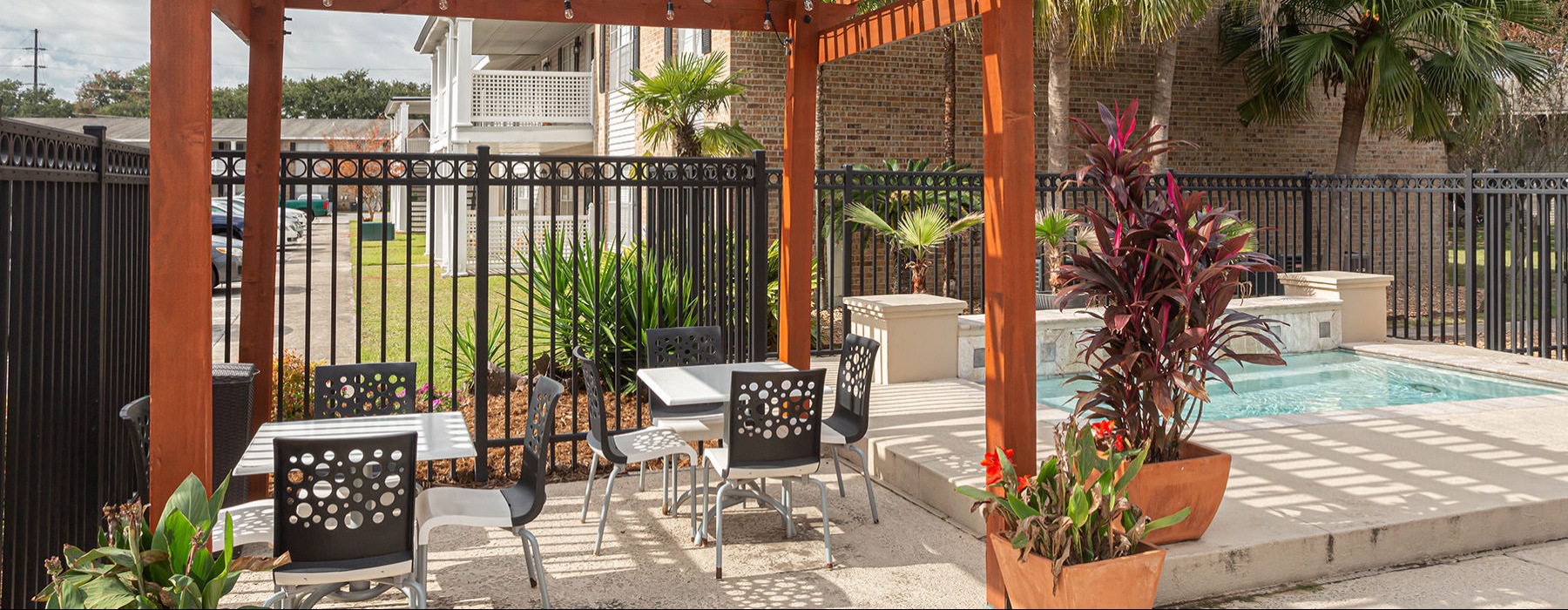 outdoor area with covering surrounded by seating and plants
